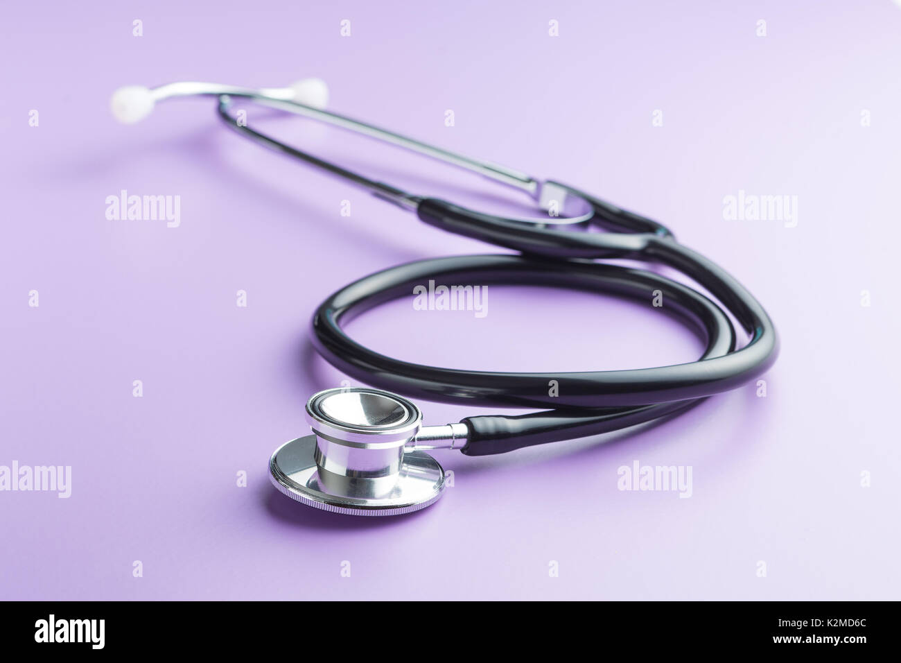Schwarz medizinische Stethoskop auf lila Hintergrund. Stethoskop Abhören des Herzens. Stockfoto