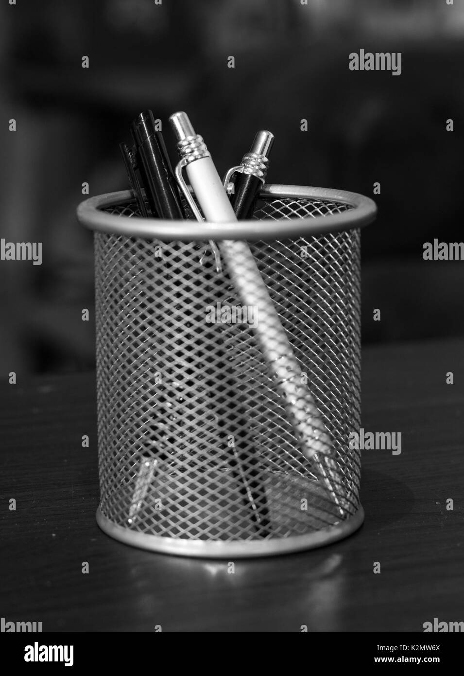 Drei elegante Stifte in einem Korb auf einem Tisch in Schwarz und Weiß. Stockfoto