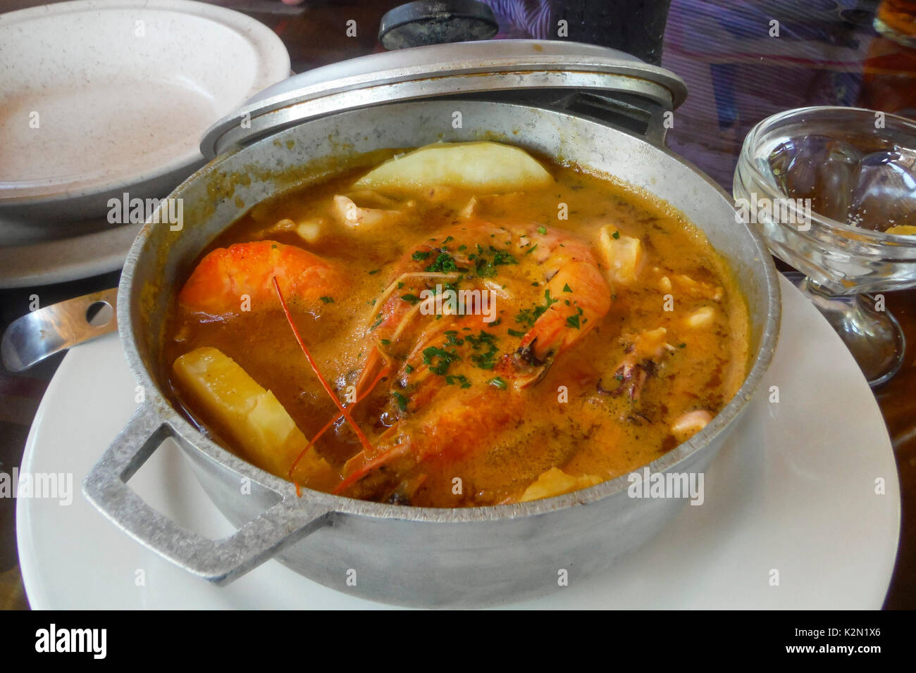 Die 'Carderada', eine Suppe aus Meeresfrüchten und Kartoffeln, gekocht und in einen Kessel serviert. Olon Strand. Ecuador. Stockfoto