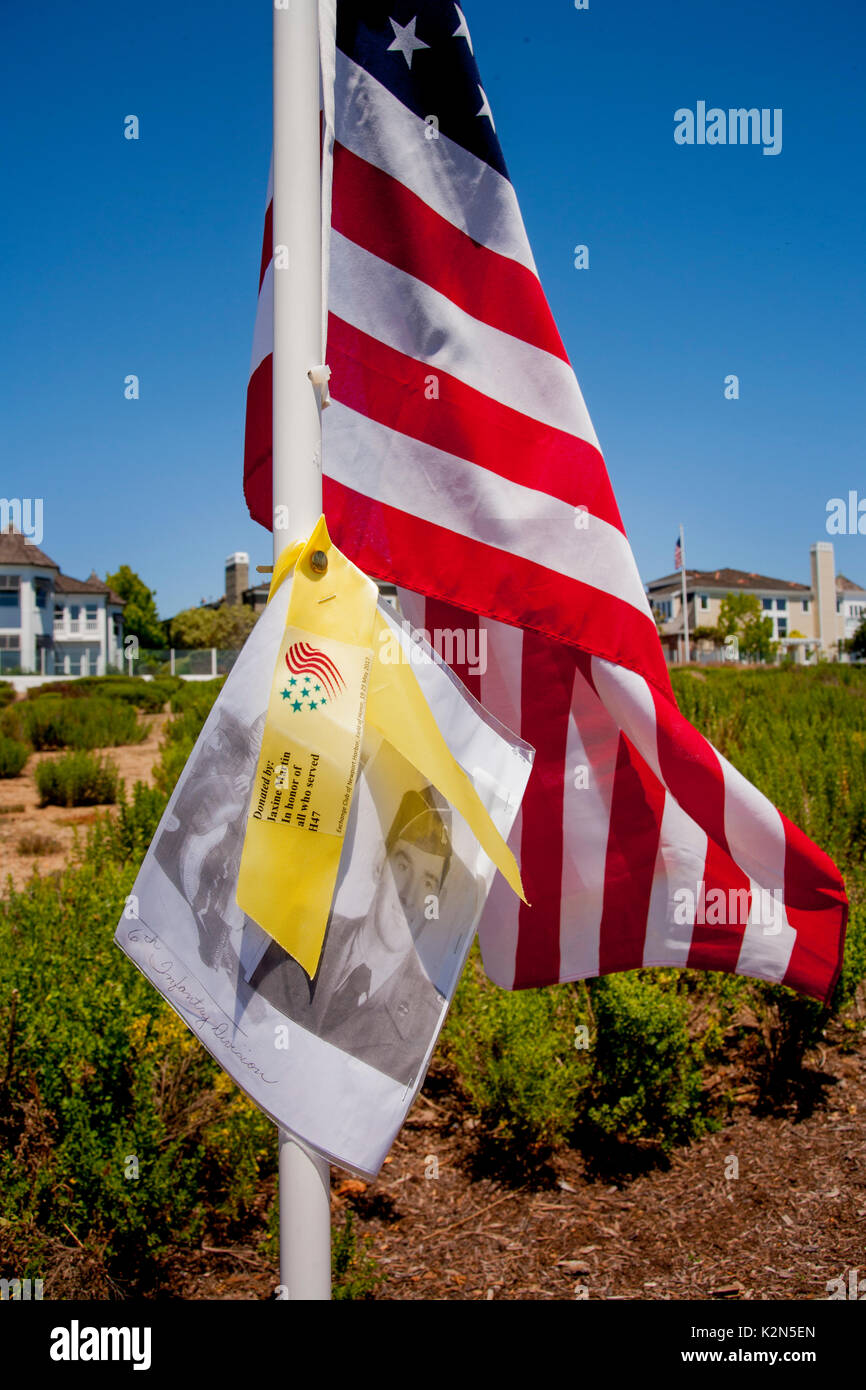 Ein Tag des Gedenkens an den Tribut in Newport Beach, CA, beinhaltet eine amerikanische Flagge, ein gelbes Band und ein Vintage Porträt eines verstorbenen Zweiten Weltkrieg uniformierte Soldaten. Stockfoto