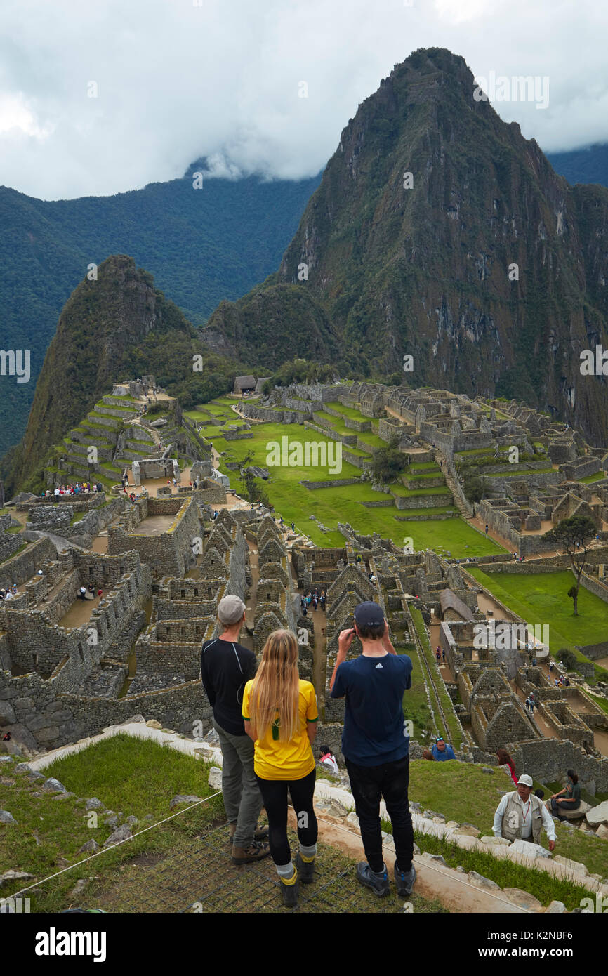Touristische Familie in Machu Picchu, Inka Ruinen aus dem 15. Jahrhundert (Weltkulturerbe), das Heilige Tal, Peru, Südamerika (MR) Stockfoto