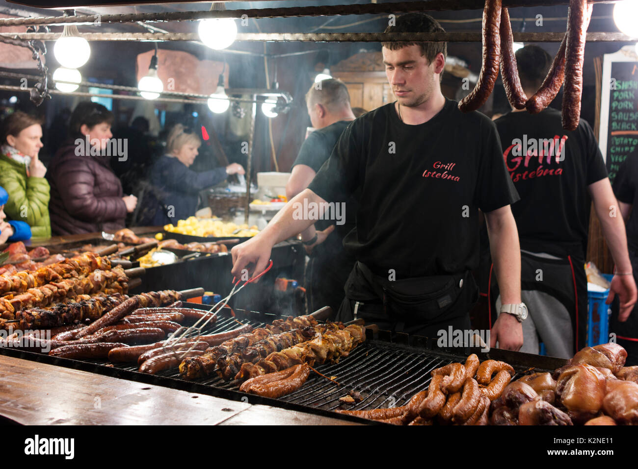 Kunden Schlange essen zu bestellen, während Männer Fleisch auf dem Markt Grill während Palmsonntag feiern in Krakau Square bei Nacht. Stockfoto