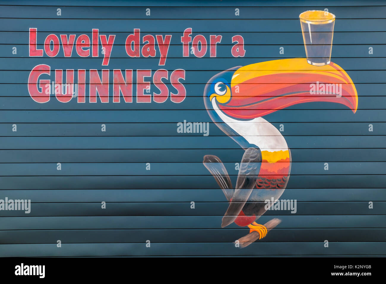Malte Guinness Schild mit einem Slogan und eine toucan Balancing ein Bier auf einer Wand in Orillia Ontario Kanada. Stockfoto