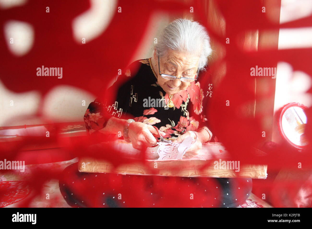 (170831) - yantai, Aug 31, 2017 (Xinhua) - Lin Guimao, 103, macht papercuttings in Yantai, Provinz Shandong, China, August 30, 2017. Lin gelernt papercutting Fähigkeiten als Kind, und jetzt immer noch gerne das Hobby. (Xinhua / Shen Jizhong) (Ry) Stockfoto