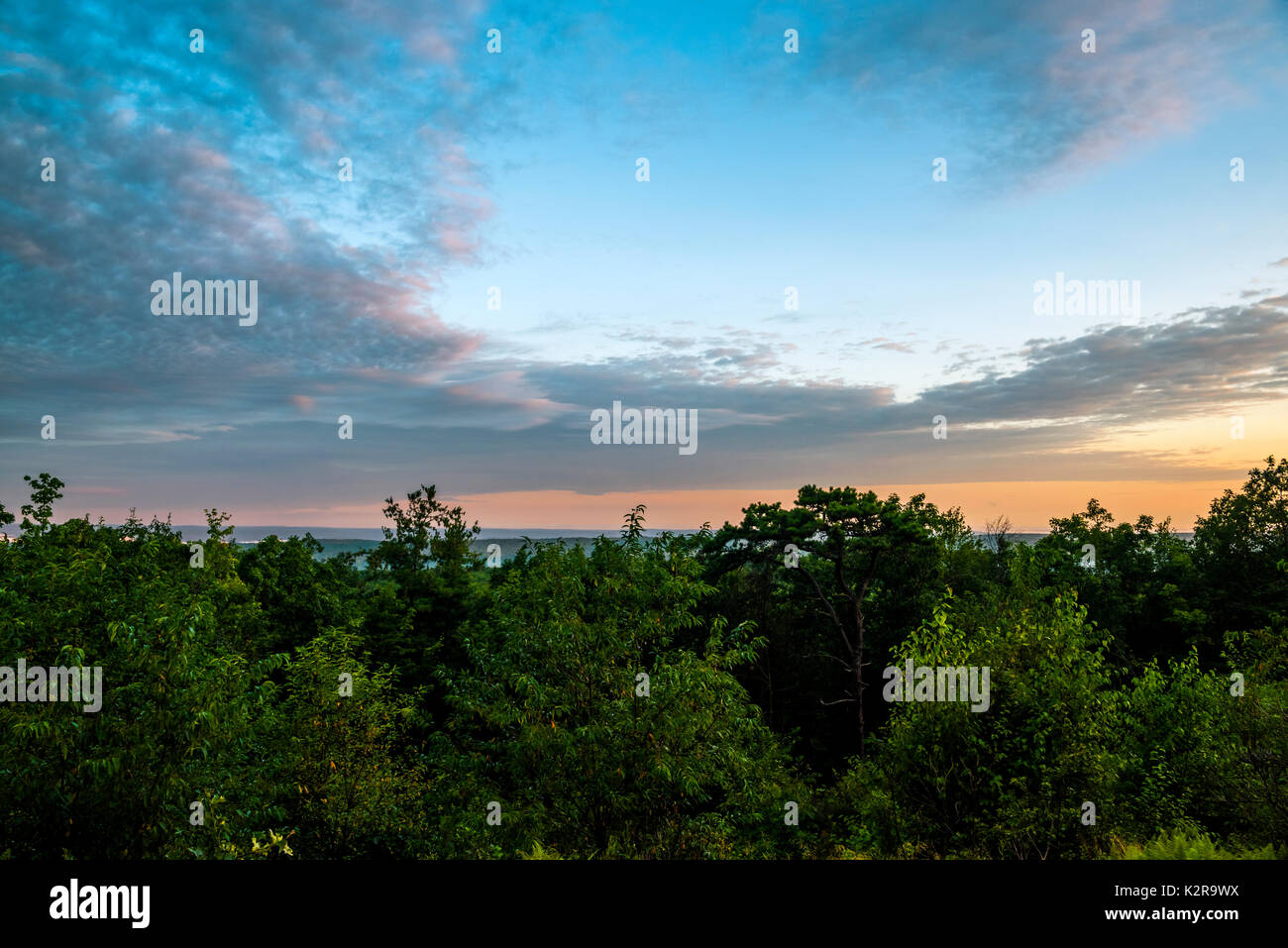 Tolle Aussicht von Sonnenaufgang Berg in New Jersey. Herzförmige Wolken, die über den Bäumen Stockfoto