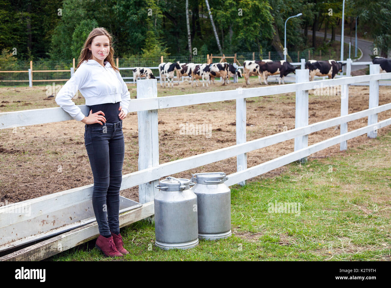 Freiheit Mädchen sitzend auf Zaun. Pause nach der Arbeit in der Milch auf dem Bauernhof. Stockfoto