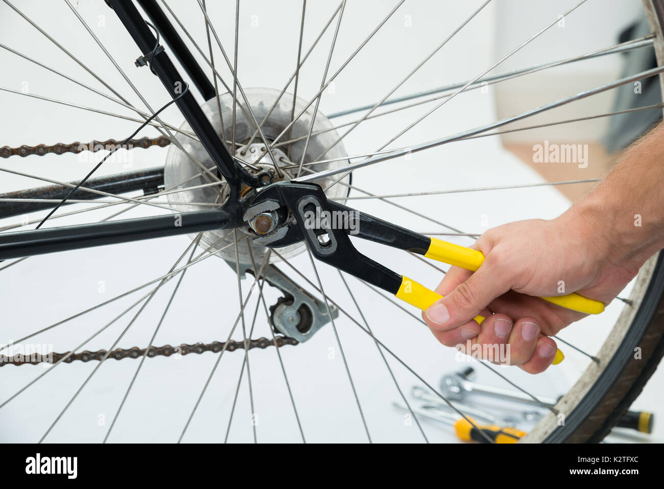 Nahaufnahme der Person Hände zur Festsetzung Fahrrad Rad mit Zange Stockfoto