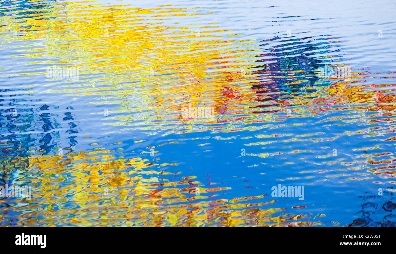 Wellige Wasseroberfläche mit bunten Reflexionen, abstrakten Hintergrund Foto Textur Stockfoto