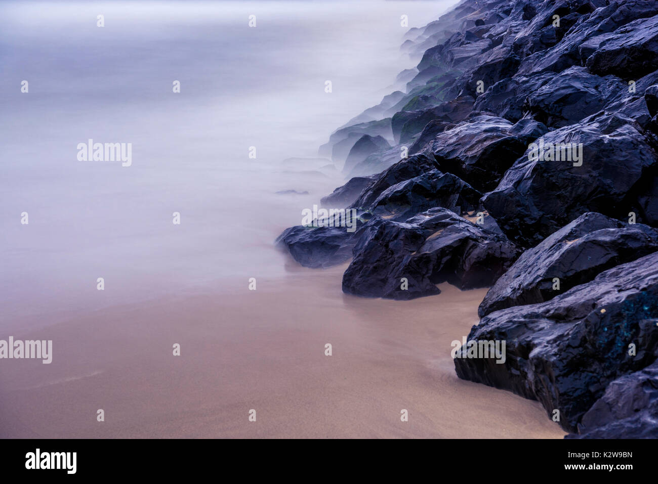 Abstrakte Ozean Hintergrund. Ozean, Steine und Sand lange Belichtung Hintergrund. Bild wurde direkt nach dem starken Regen am Strand. Stockfoto