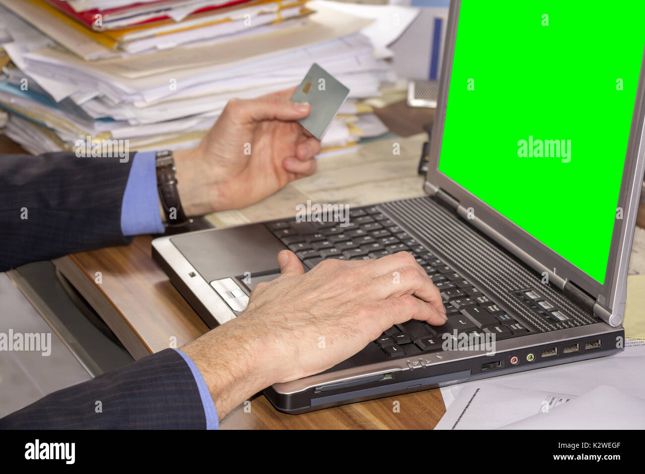 Business Mann online einkaufen, mit Laptop und Kreditkarte auf Green Screen Stockfoto