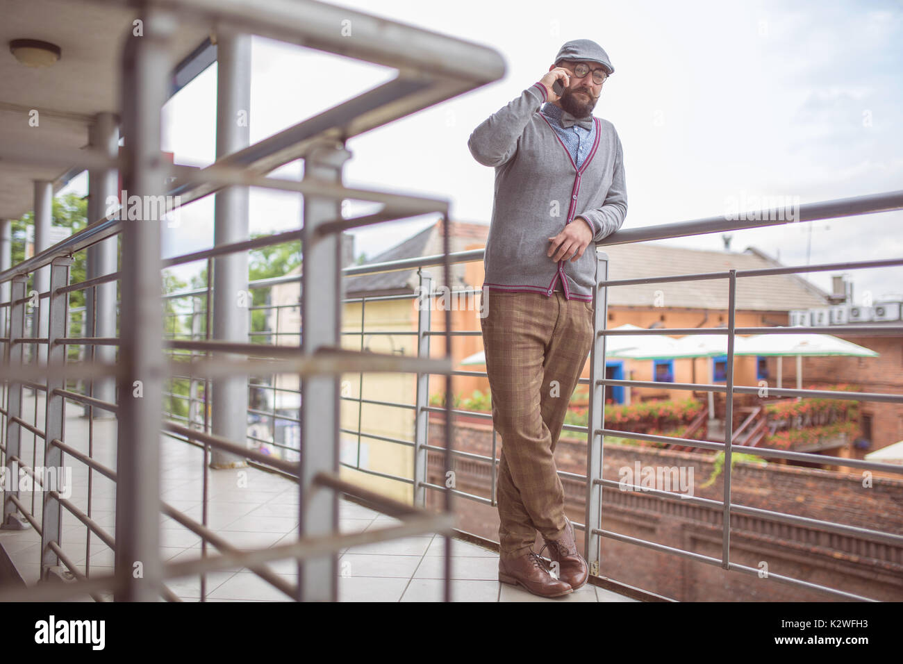 Mann, der stilvolle Kleidung, am Telefon zu sprechen auf der Terrasse Stockfoto