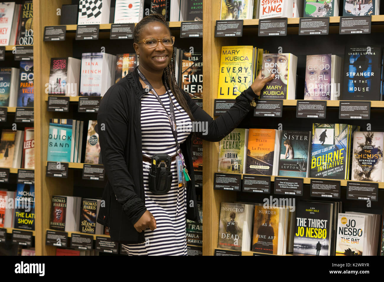 Eine attraktive, kenntnisreich hilfsbereite Angestellte an der kürzlich eröffneten Amazon Book Store auf W. 34th St in Manhattan, eine seltene Amazon Brick & Mortar store. Stockfoto