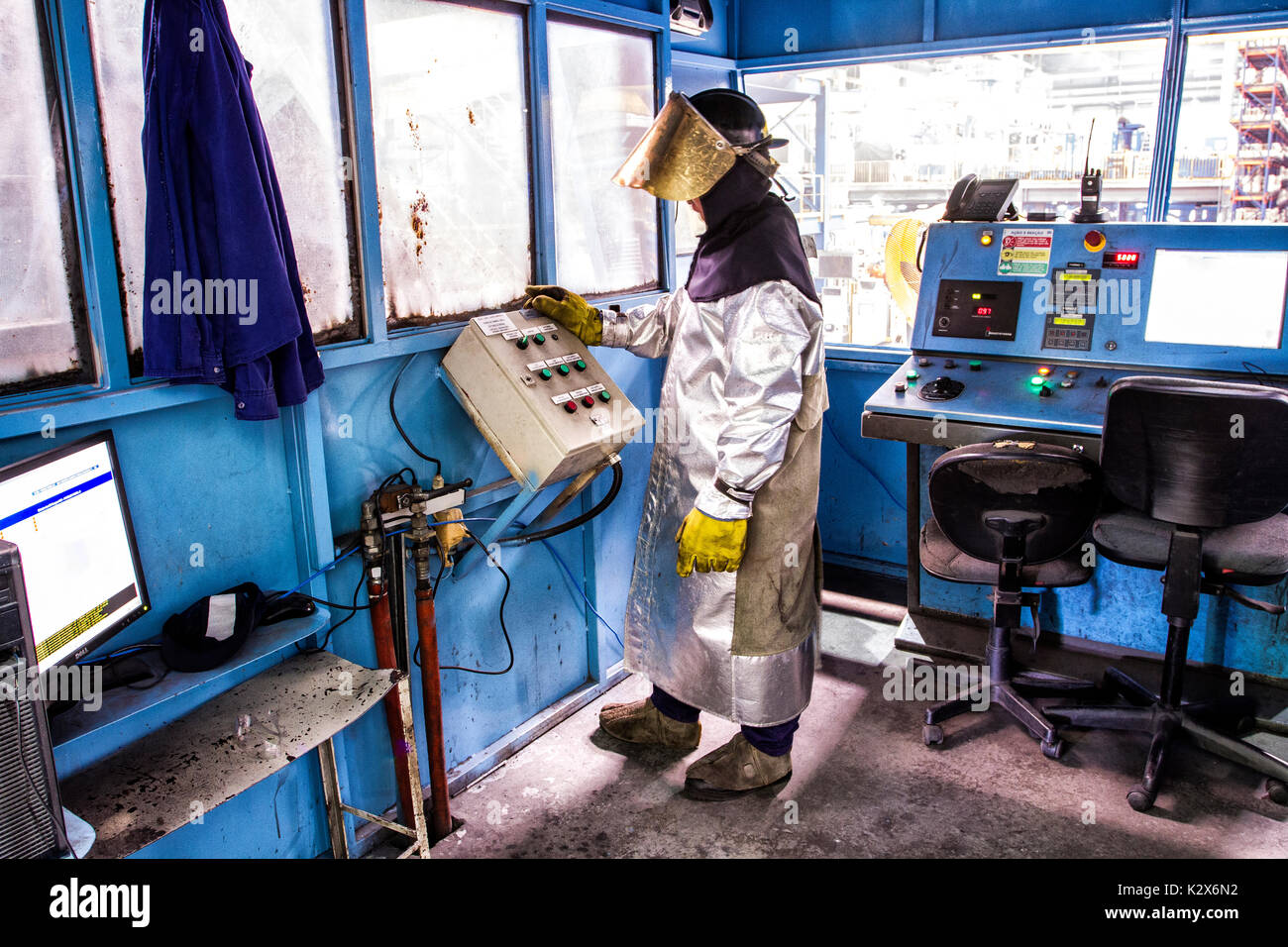 Mann, der eine Schutzausrüstung Betrieb einer Maschine in der Metallurgie. Guaramirim, Santa Catarina, Brasilien. Stockfoto