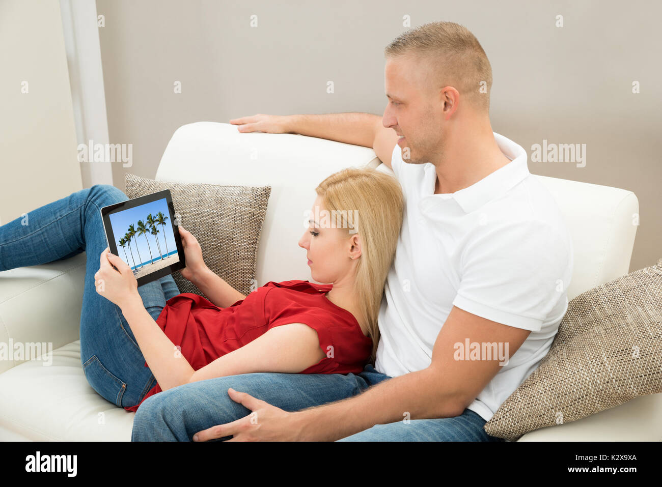 Junges Paar auf Sofa Video auf digitalen Tablet Stockfoto