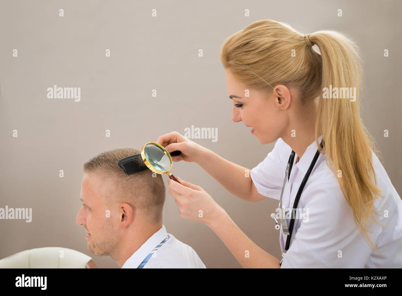 Close-up weiblichen Dermatologe an der Patientin Haare durch Lupe suchen Stockfoto