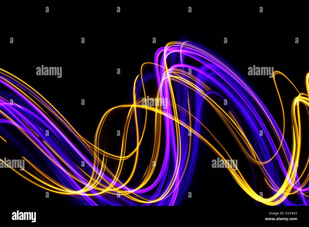 Purpur und Gold Licht Malerei Fotografie - lange Exposition gegen einen sauberen schwarzen Hintergrund Stockfoto