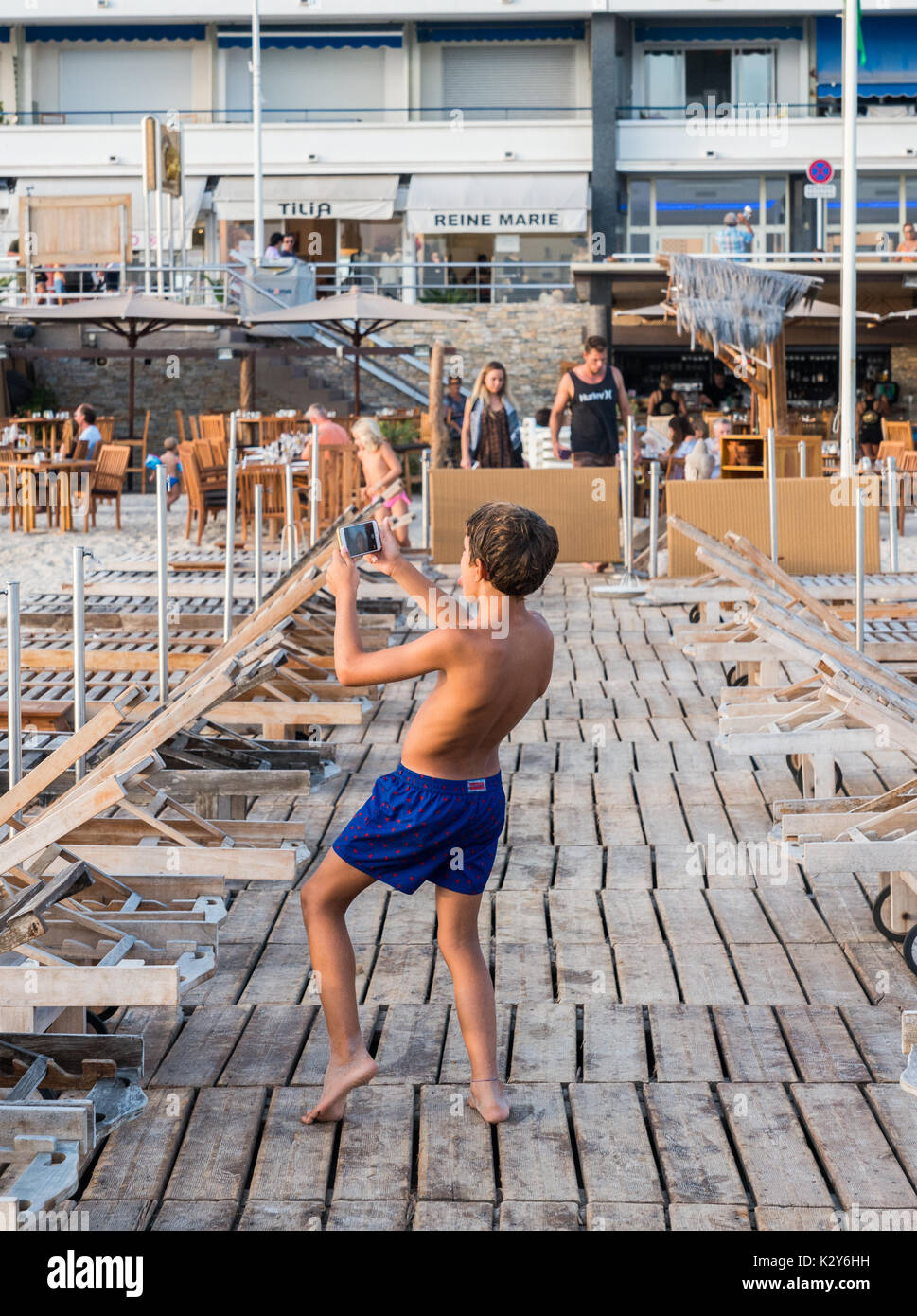 Ein kleiner Junge nimmt eine dumme selfie auf einem Pier in Juan-les-Pins, Frankreich Stockfoto