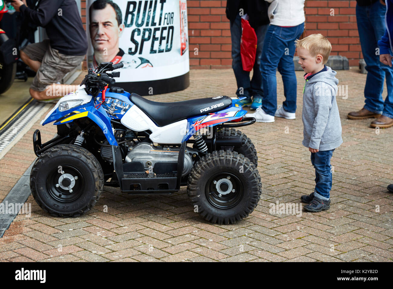 Kleiner Junge schaut auf bei John McGuinness' mini quad bike an der Manx Classic TT Rennen, von der Insel Man Stockfoto