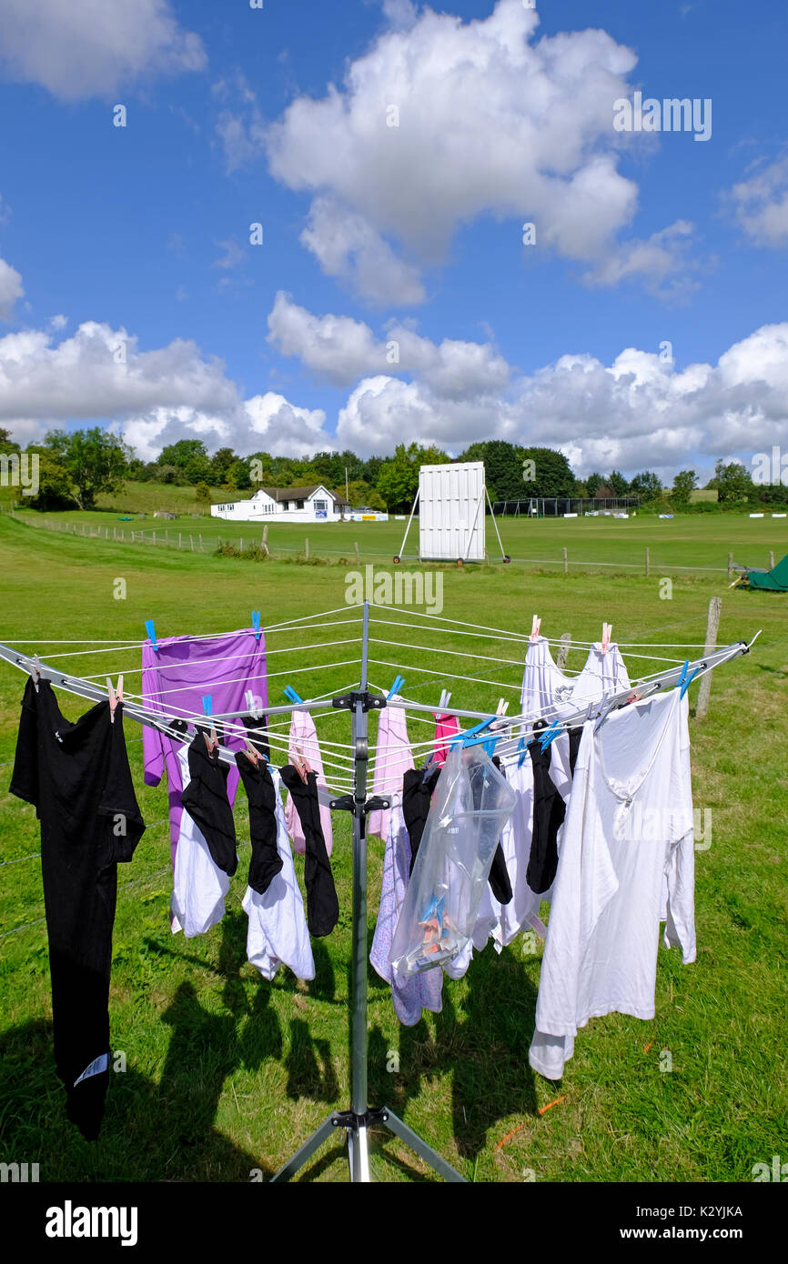 Waschmaschine auf einem Campingplatz mit Cricket Club im Hintergrund. Sussex, UK Stockfoto