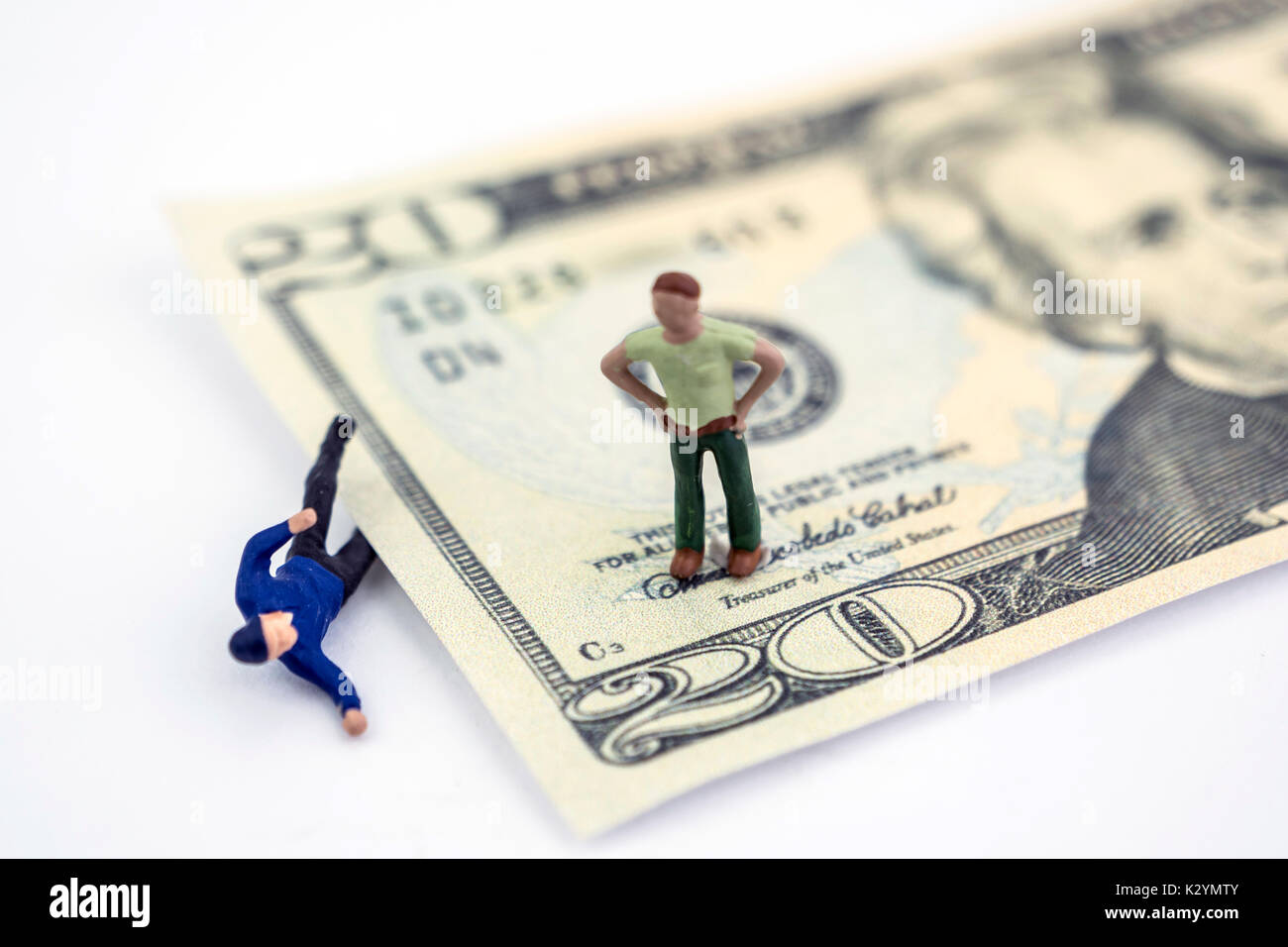 Ein Dollar Bill zerquetscht eine Miniatur Mann, ein Mann über suchen, isolierte leer Konzept Stockfoto