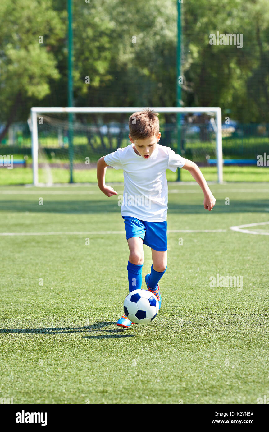 Junge Fußballspieler mit Ball auf Fußball-Stadion Stockfoto