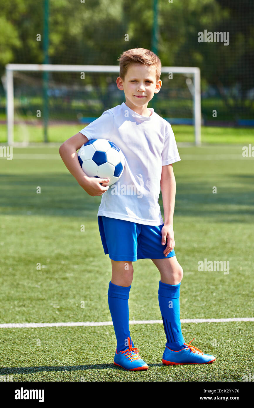 Junge Fußball-Fußball-Spieler mit Ball auf dem grünen Rasen des Stadions Stockfoto