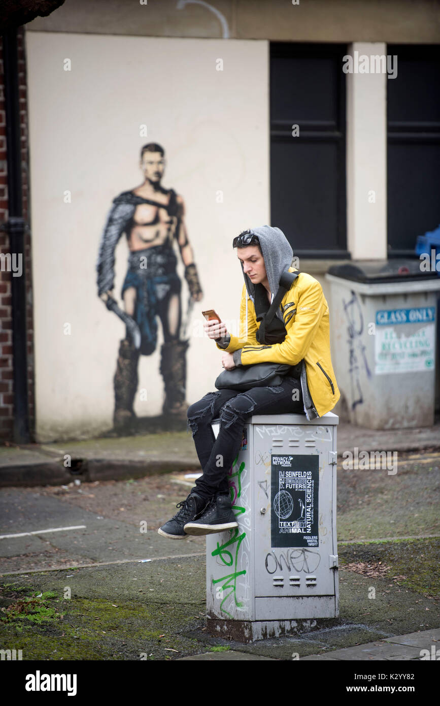 Junge Person mit Handy im Frogmore Street, Bristol, Großbritannien Stockfoto