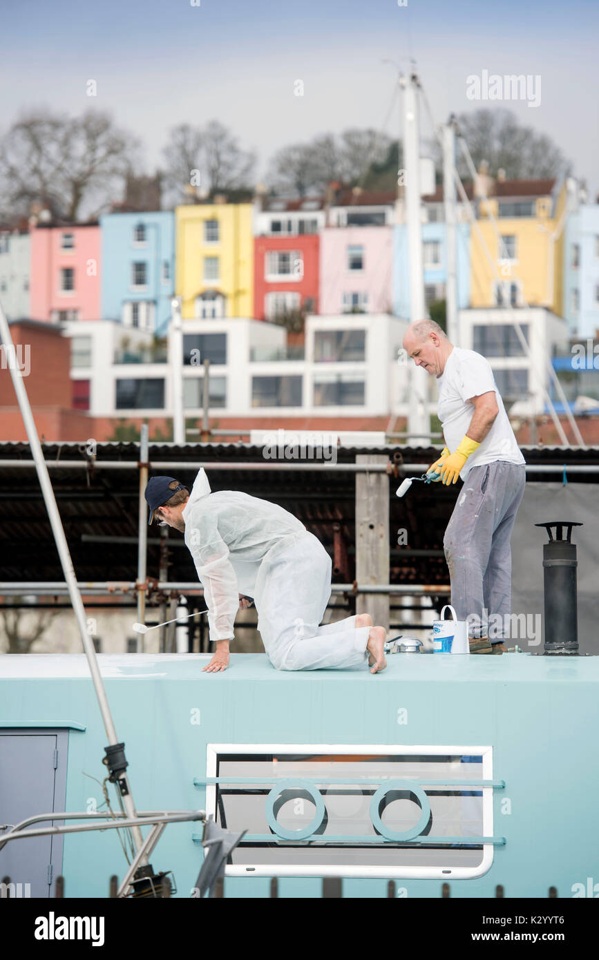 Zwei Männer malen ein Boot an der Bristol Marina, Großbritannien. Stockfoto