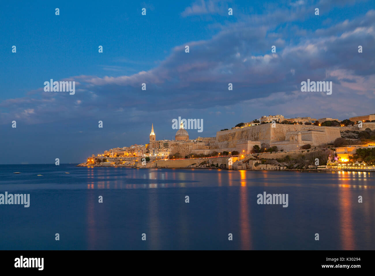 Sommer tolle Nacht Blick auf Valetta Profil über Meer. Lange Belichtung. Beleuchtete Architektur. Stockfoto