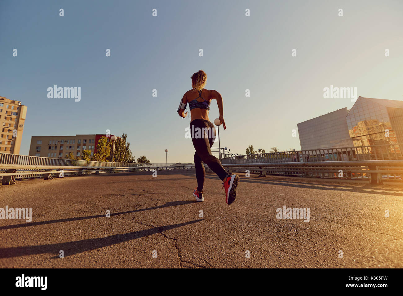 Eine Frau Läufer joggen auf einer Brücke in der Stadt Stockfoto