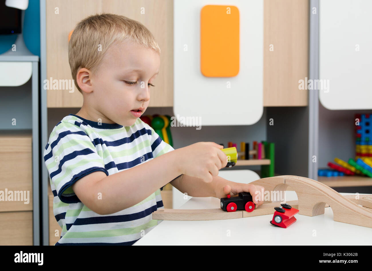 Kind Junge mit Holzzug im Kindergarten spielen. Kind Baby Spielzeug Zug Kindergarten oder Wohnkonzept spielen Stockfoto