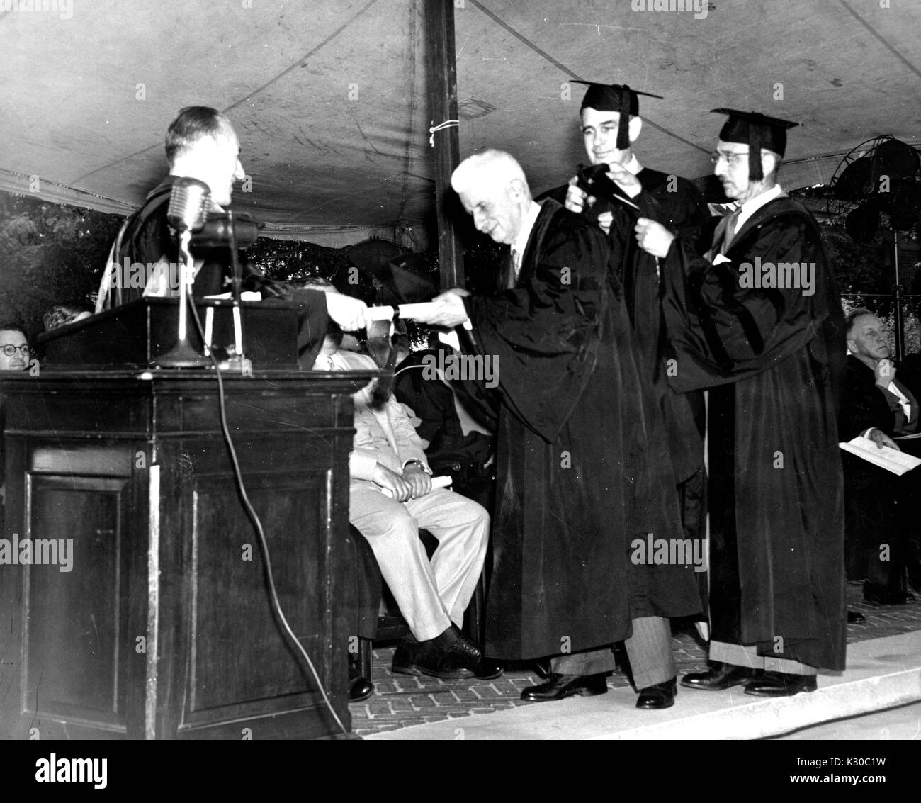 Philosoph und Professor Arthur Oncken Lovejoy erhält eine Ehrenurkunde von fellow Johns Hopkins Philosophie Professor George Boas während der Klasse der Universität Anfang Zeremonie 1951, 12. Juni 1951. Stockfoto