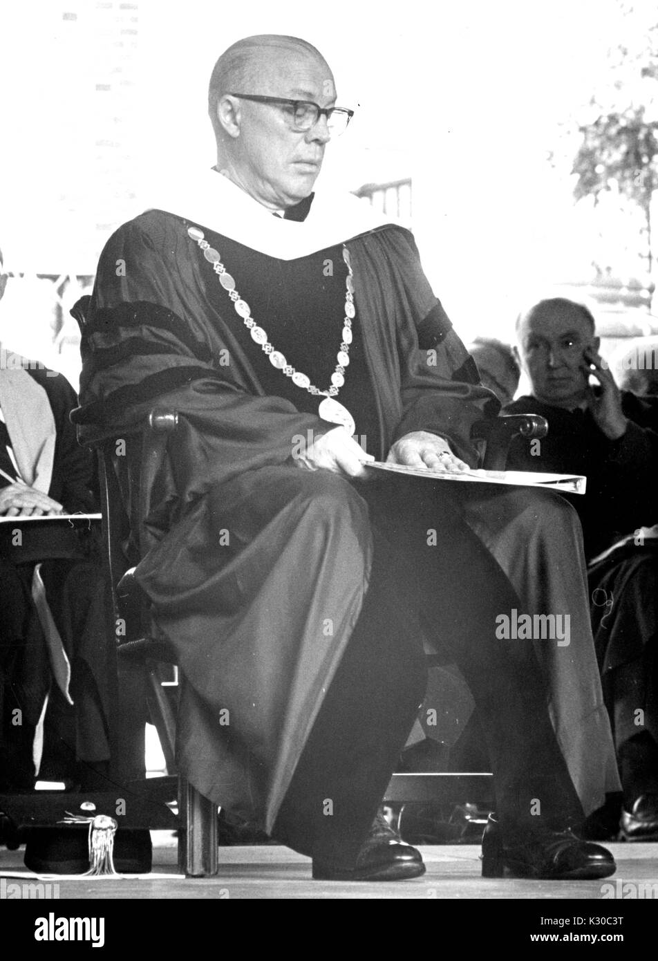 Zu Beginn Tag, Präsident der Johns Hopkins University Milton Stover Eisenhower sitzt auf der Bühne tragen Graduierung Gewand und -Medaille, der an seinem bereit, Erläuterungen, Baltimore, Maryland, 13. Juni 1967 zu werfen. Stockfoto
