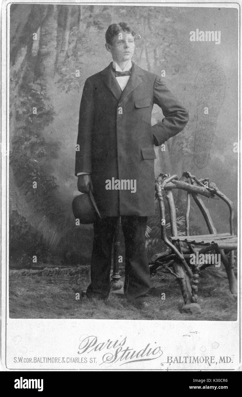 Charles Angelo Conrad, Rechtsanwalt und studierte an der Johns Hopkins Universität, stellt für sein Porträt in einem Studio mit inszenierten Gras und Lehrstuhl für Holz- Zweigen, in einem Anzug hält seinen Hut, Baltimore, Maryland, 1894. Stockfoto
