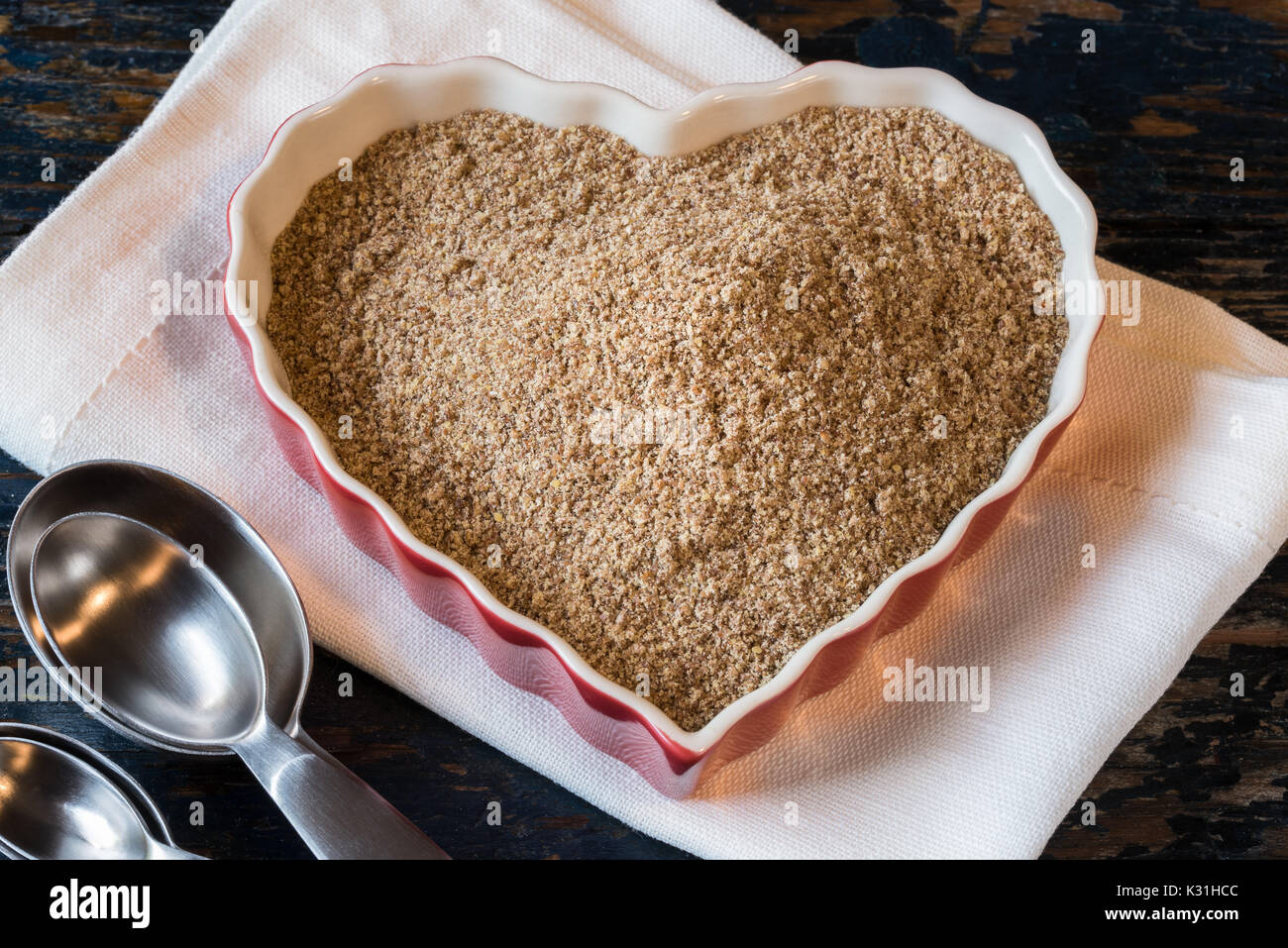 Gemahlener Leinsamen in Herzform Stockfoto