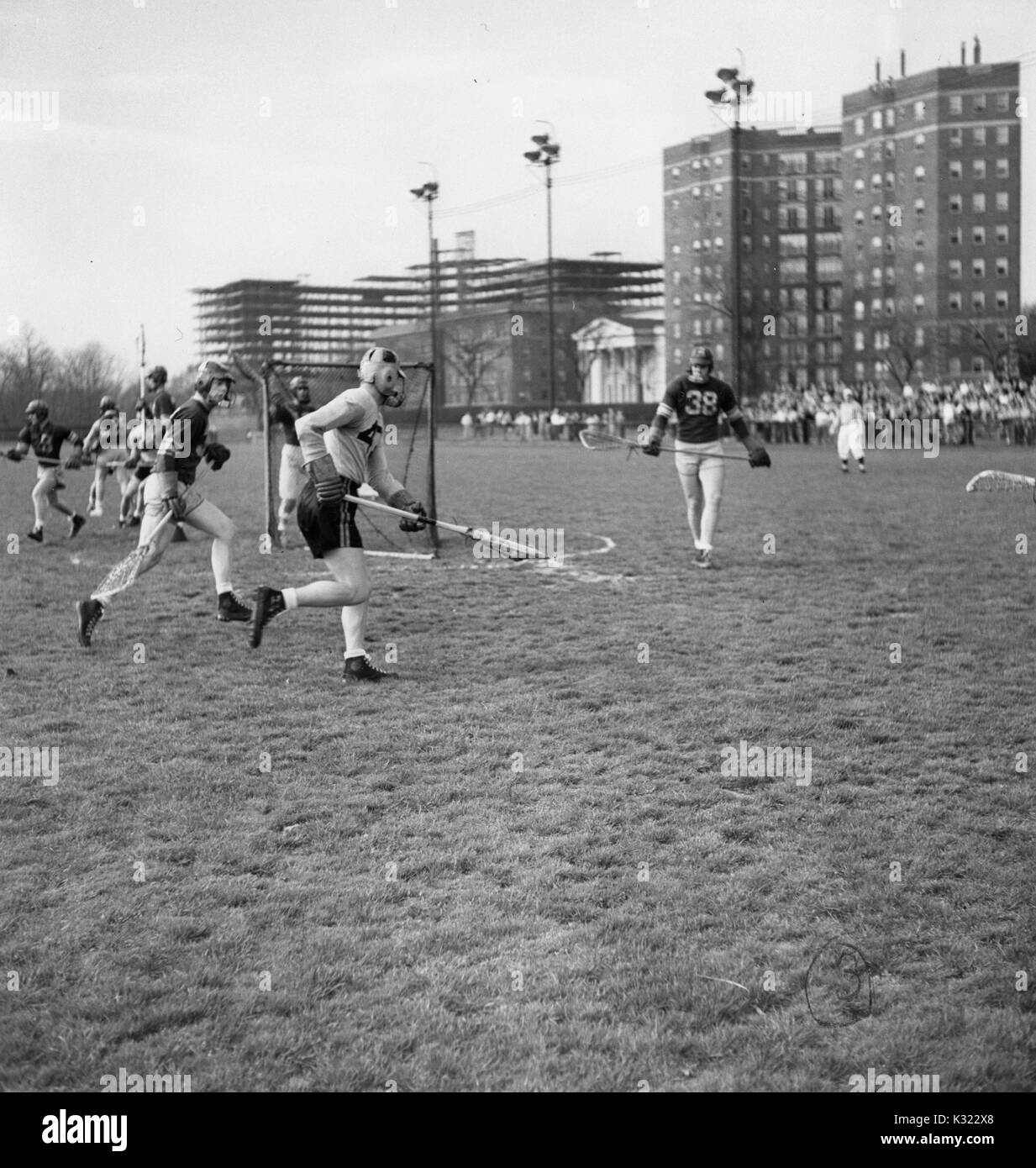 Während ein lacrosse Spiel, ein Loyola defenseman geht für Johns Hopkins Co - Kapitän und attackman Byron Forbush (Keine, Juni, 1951. 47), auf dem Homewood Feld in Baltimore, Maryland. Stockfoto