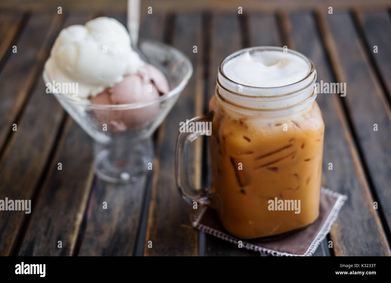 Eiskaffee mit Eis auf Holztisch, selektiver Fokus auf Kaffee Tasse, Sommer Dessert Stockfoto