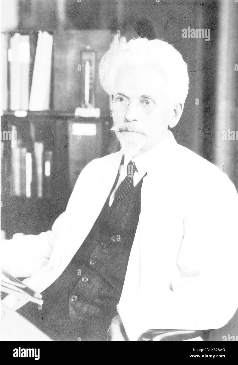 Ehrliches Porträt der amerikanischen Neurowissenschaftler Henry Herbert Donaldson sitzen an einem Schreibtisch vor Bücherregale, 1916. Stockfoto
