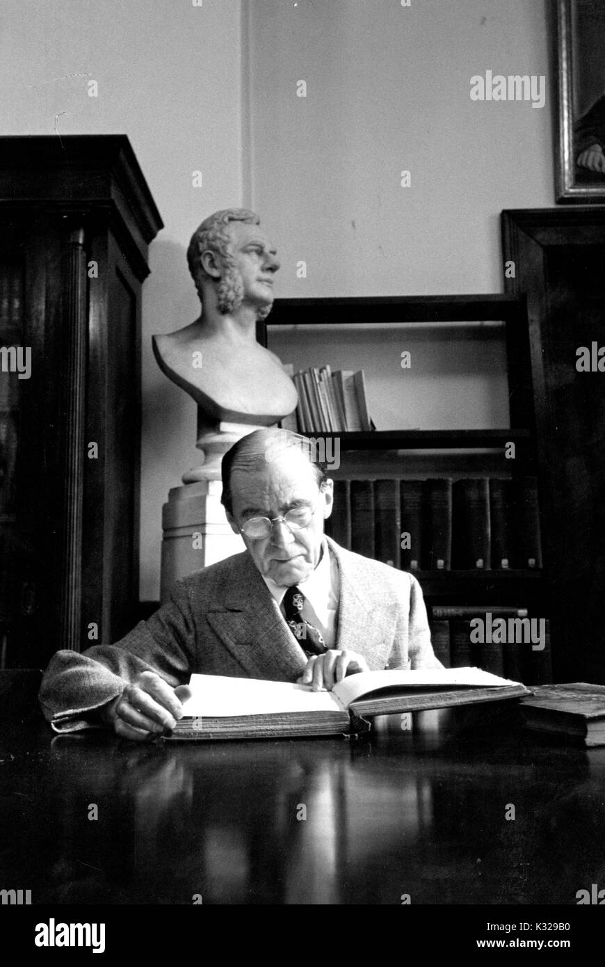 Candid Portrait von Paul Emile Dumont, Professor für Sanskrit und Indologie an der Johns Hopkins University, am Schreibtisch lesen, 1951 sitzen. Stockfoto