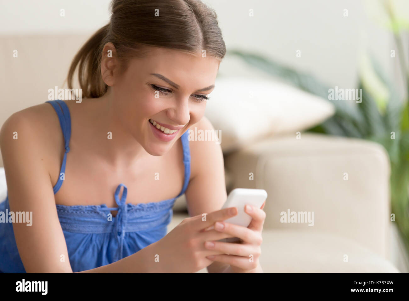 Frau spielen mobile Spiele auf Handy zu Hause Stockfoto