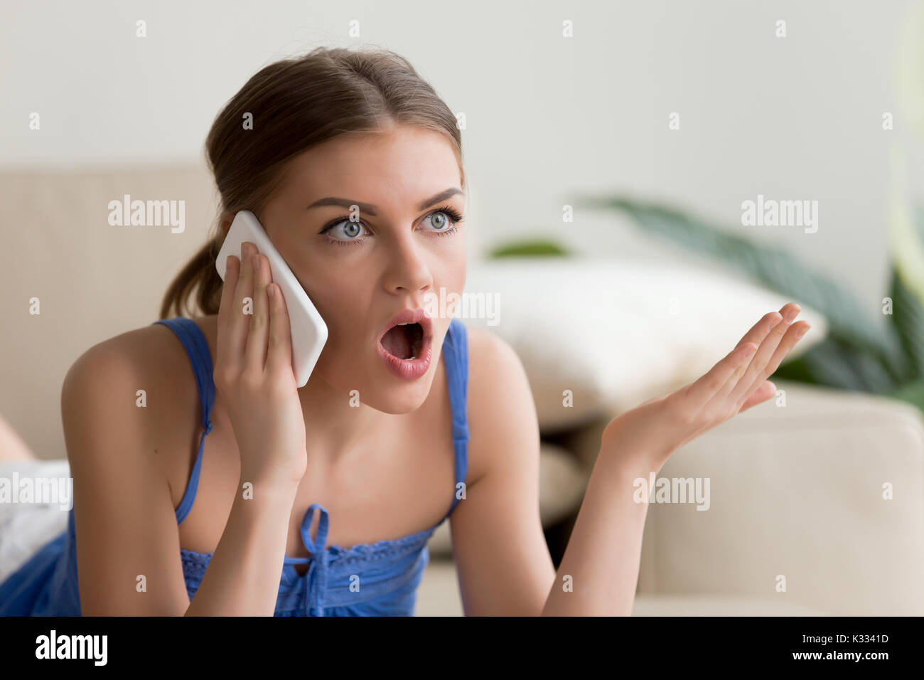 Überrascht junge Frau Gespräch am Handy Stockfoto