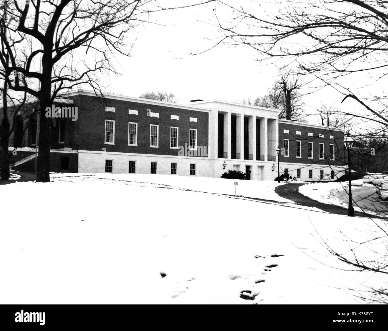 Suche nach Nordwesten, Milton S Eisenhower Bibliothek, die mehrere Ebenen u-Verlängerung, steht an der Spitze der grasbewachsenen Hügel an der Vorderseite der Johns Hopkins Universität, die in den Schnee im Winter, Baltimore, Maryland, 1965 abgedeckt. Stockfoto