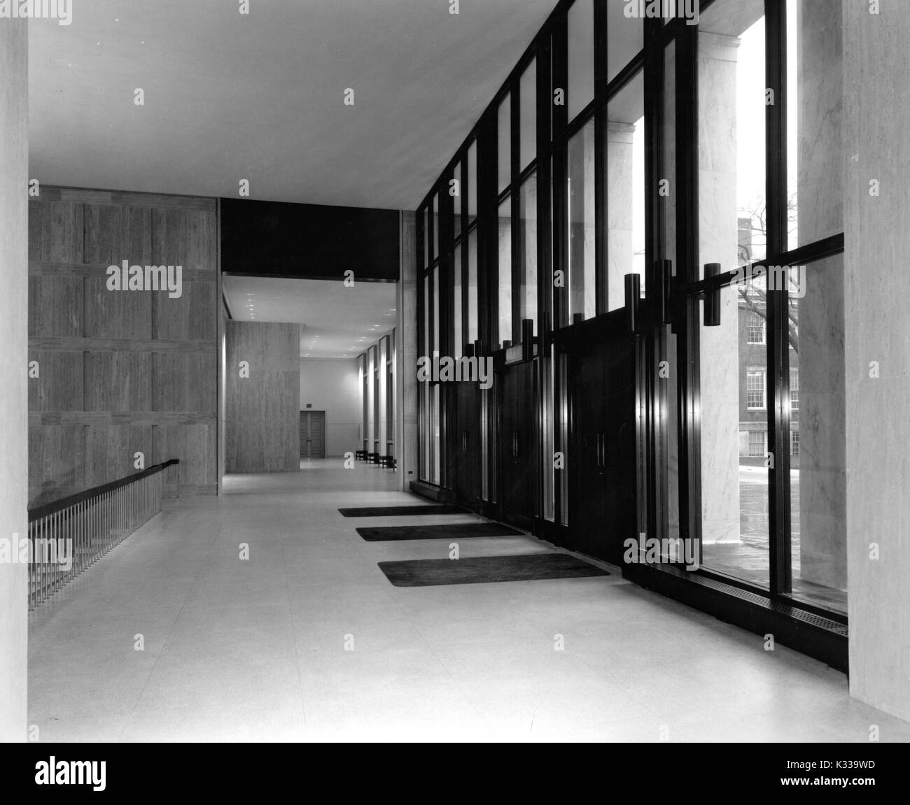 In der neu eröffneten Milton S Eisenhower Bibliothek an der Johns Hopkins University, die unberührten Eingangsbereich aus Marmor auf Q-Ebene, auf der Terrasse, mit großen Glastüren, ein Geländer zu M-Ebene unten und Matten vor der Türöffnung, Baltimore, Maryland, September, 1964. Stockfoto