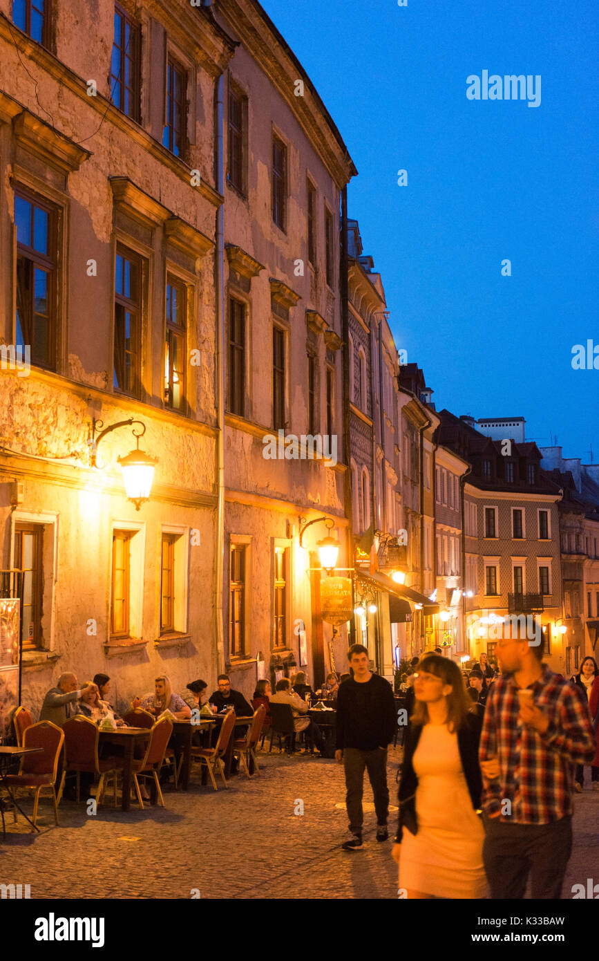 Einheimische, Besucher und Urlauber zu Fuß am Abend in der Altstadt von Lublin entfernt. Die Krakauer Tor ist im Hintergrund. Stockfoto