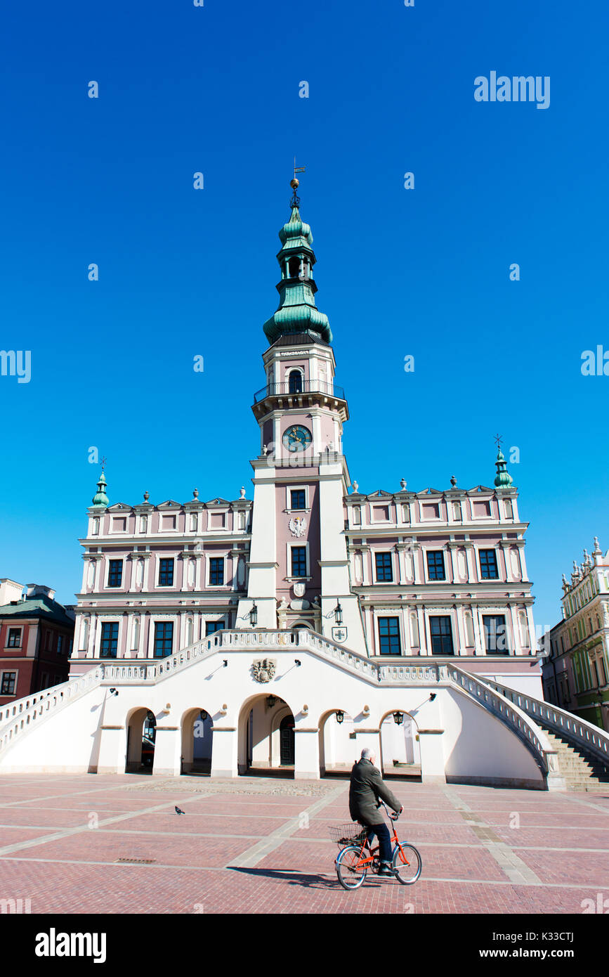 Ein Mann Zyklen über den Hauptplatz in Zamosc, eine Renaissance der Stadt im Südosten Polens, ein UNESCO-Weltkulturerbe. Stockfoto