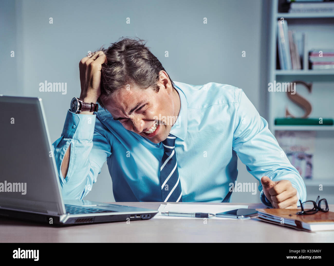 Geschäftsmann mit verzweifelten der Mimik, Leiden, Stress und Kopfschmerzen. Foto junger Mann bei der Arbeit im Büro. Business Konzept Stockfoto