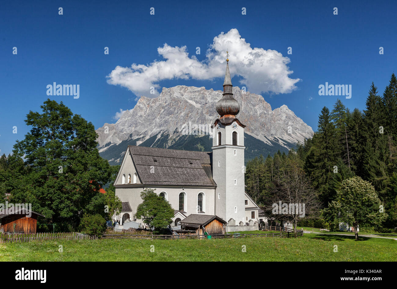 Typische Kirche alpinen Dorfes umgeben von Gipfeln und Wald Garmisch Partenkirchen Oberbayern Region Bayern Deutschland Europa Stockfoto