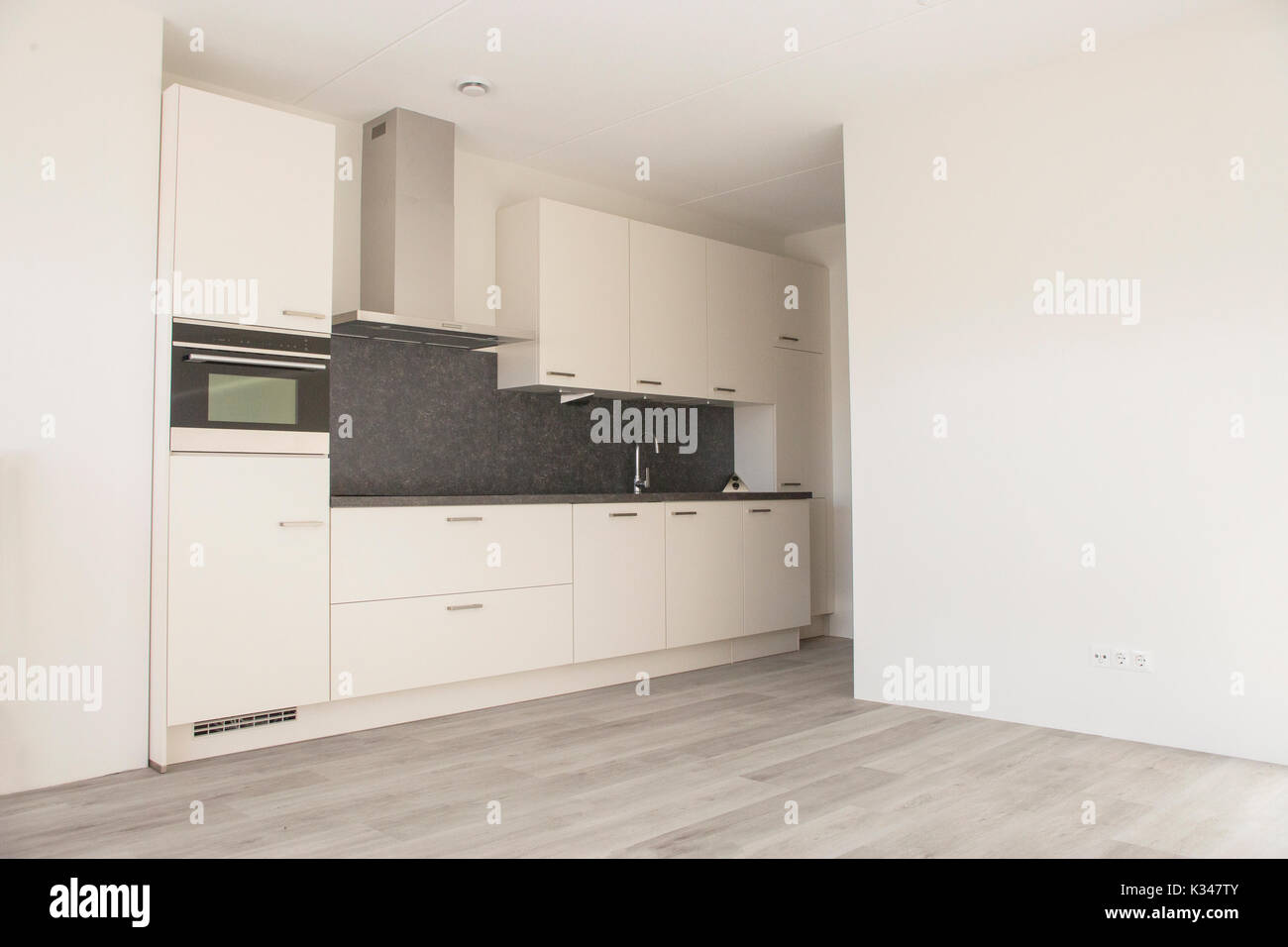 Moderne, weiße Küche in neues, leeres Haus mit Holzboden Stockfotografie -  Alamy