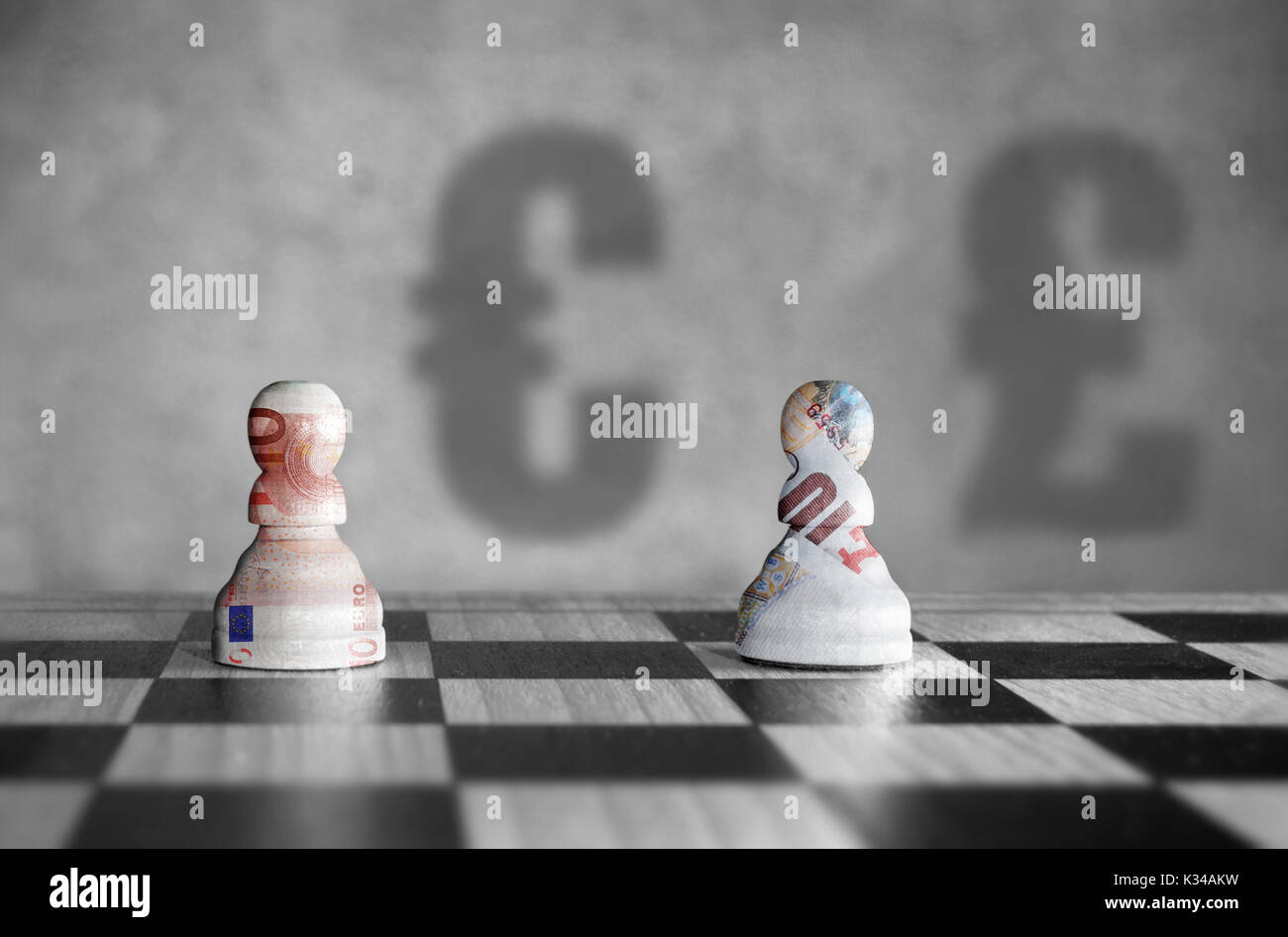 Schachfiguren mit Euro verus pound Währungssymbol Schatten im Hintergrund Stockfoto