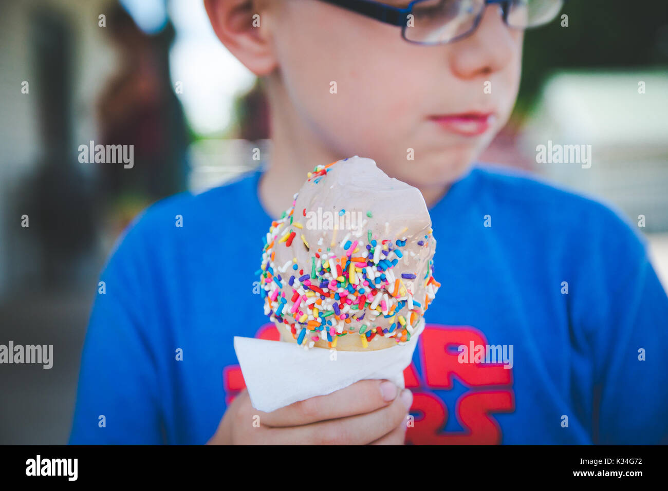 Ein Junge isst ein Eis während der wärmeren Jahreszeit. Stockfoto